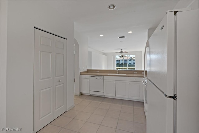 kitchen with sink, white appliances, white cabinets, and light tile patterned floors