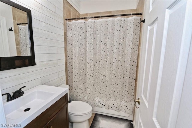 15578 Vallecas Ln, Naples, FL 34110 - bathroom with wood walls, vanity, toilet, and shower / bath combo with shower curtain