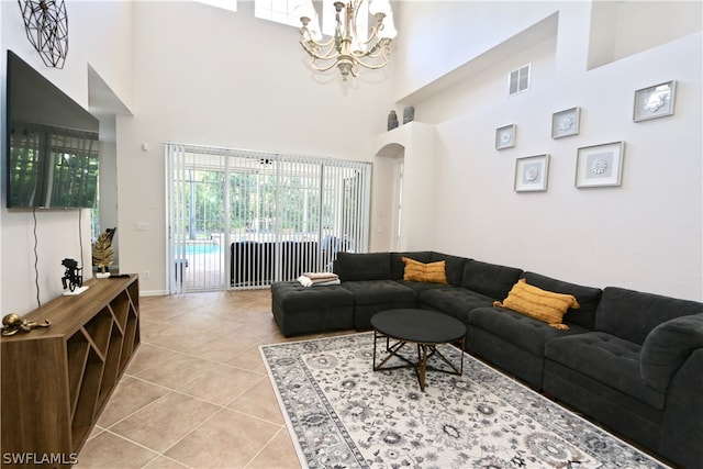 tiled living room with a high ceiling and an inviting chandelier