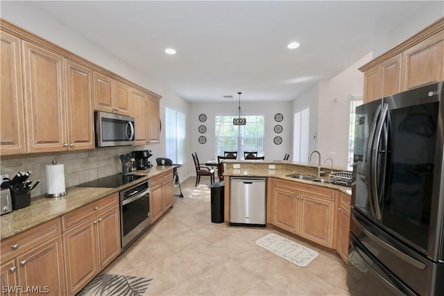 15578 Vallecas Ln, Naples, FL 34110 - kitchen featuring black appliances, a sink, a peninsula, light stone counters, and backsplash