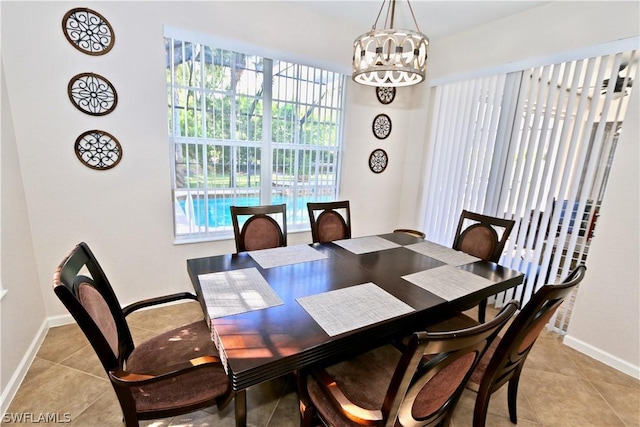 15578 Vallecas Ln, Naples, FL 34110 - dining space featuring light tile patterned floors, a chandelier, and baseboards