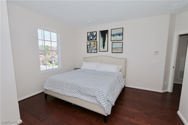 bedroom with dark hardwood / wood-style floors