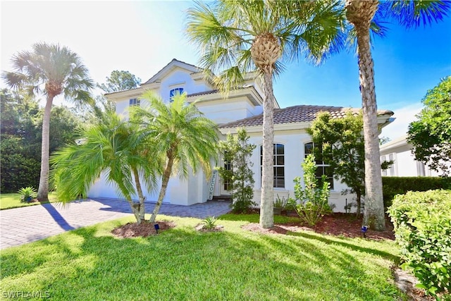 15578 Vallecas Ln, Naples, FL 34110 - view of front of home featuring a front lawn, stucco siding, a tile roof, and decorative driveway
