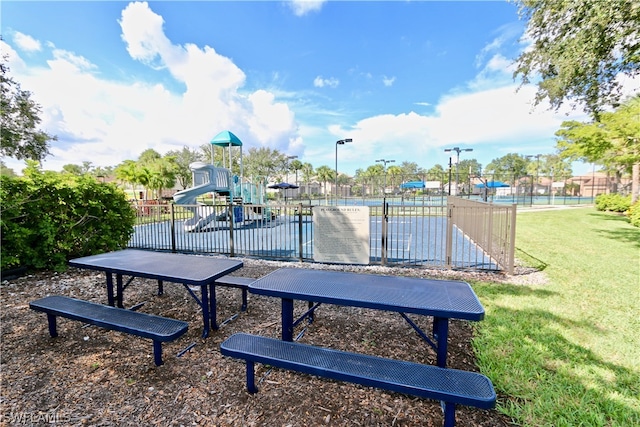 view of community featuring a yard, a swimming pool, and a playground