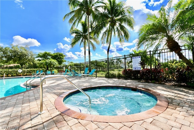 view of swimming pool with a hot tub and a patio area