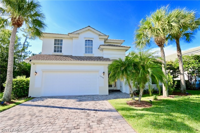 mediterranean / spanish-style house with a garage and a front lawn