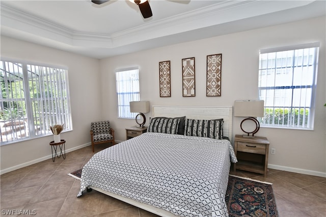 bedroom featuring tile patterned floors, ceiling fan, a raised ceiling, and ornamental molding