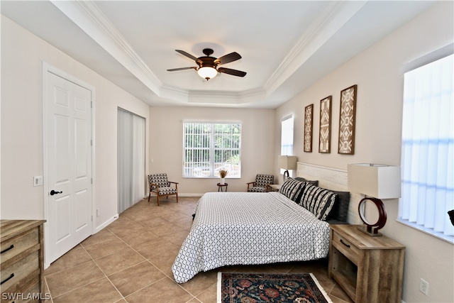 tiled bedroom with crown molding, ceiling fan, and a tray ceiling