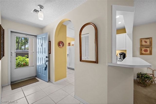 tiled foyer entrance with a textured ceiling