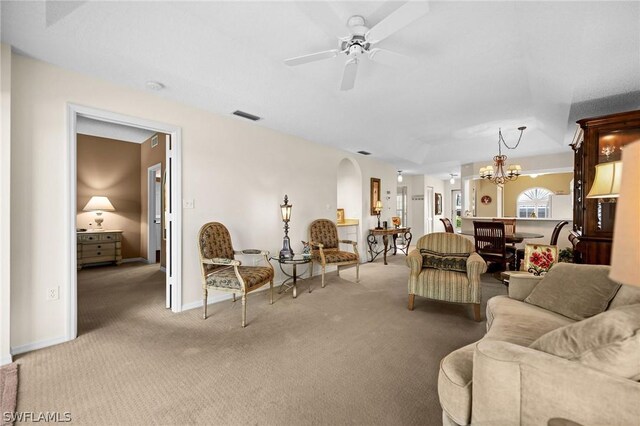 living room with ceiling fan with notable chandelier and light carpet