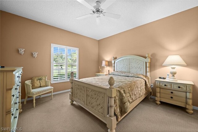 bedroom featuring ceiling fan, light colored carpet, and a textured ceiling