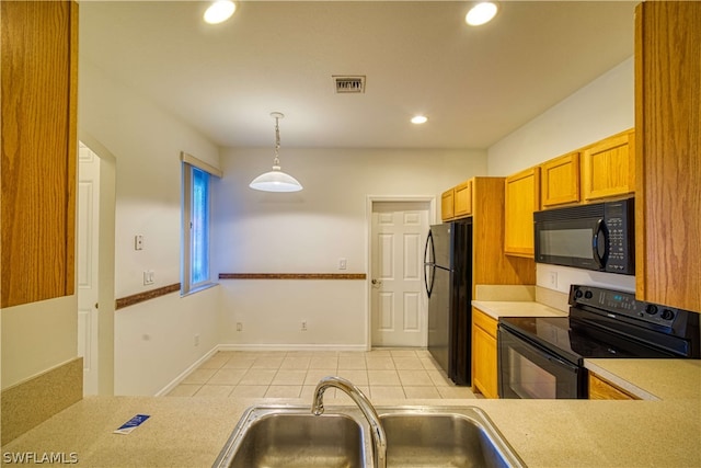 kitchen with light tile patterned flooring, sink, hanging light fixtures, and black appliances