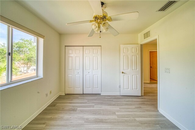 unfurnished bedroom featuring ceiling fan, light hardwood / wood-style floors, and a closet