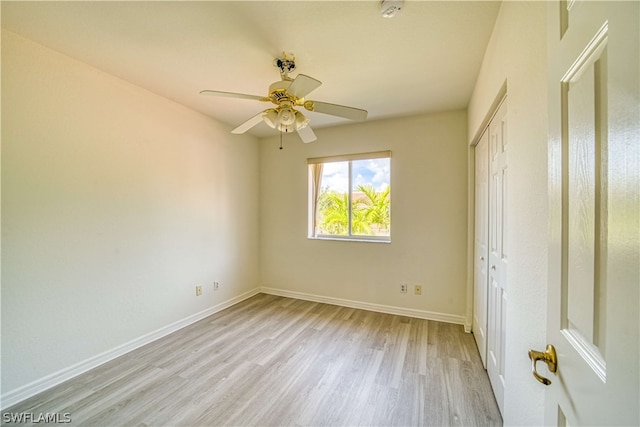 unfurnished bedroom with ceiling fan, light wood-type flooring, and a closet