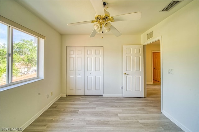 unfurnished bedroom featuring ceiling fan, a closet, and light hardwood / wood-style flooring