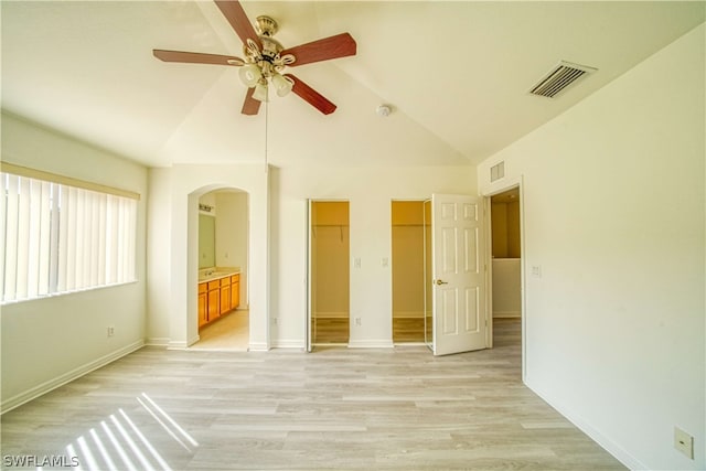 spare room featuring ceiling fan, light wood-type flooring, and vaulted ceiling