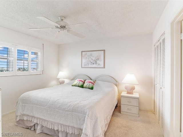 carpeted bedroom featuring ceiling fan, a textured ceiling, and a closet