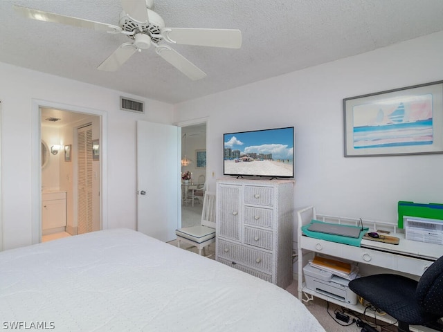 bedroom with ensuite bath, ceiling fan, and a textured ceiling