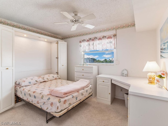 carpeted bedroom with ceiling fan and a textured ceiling