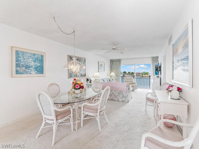 dining room with ceiling fan and light carpet