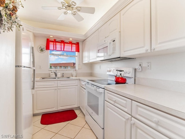 kitchen with white cabinets, light tile patterned flooring, white appliances, and sink