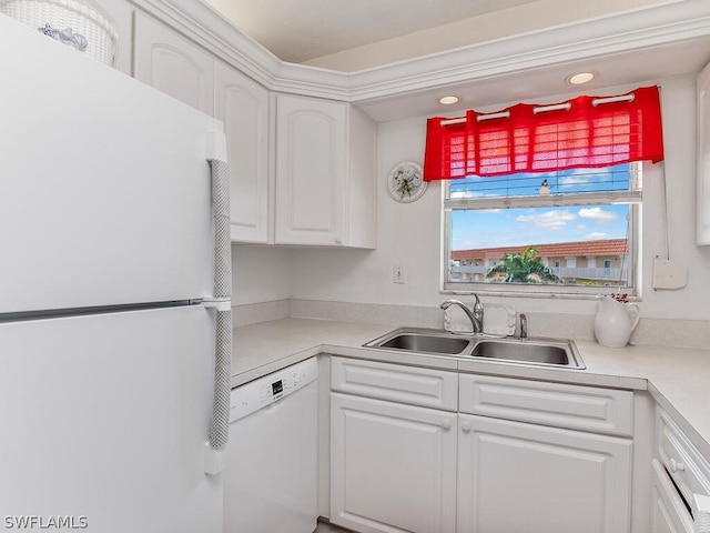 kitchen featuring white cabinetry, sink, and white appliances