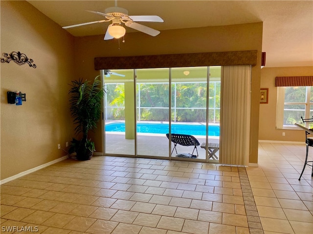 interior space featuring light tile patterned floors, vaulted ceiling, and ceiling fan