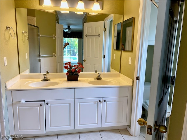 bathroom featuring tile patterned flooring, dual vanity, toilet, and ceiling fan