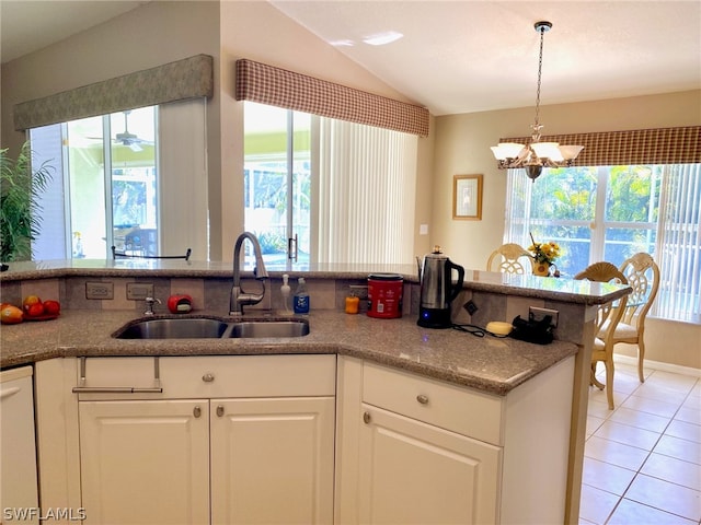 kitchen featuring white cabinets, sink, white dishwasher, vaulted ceiling, and light tile patterned floors