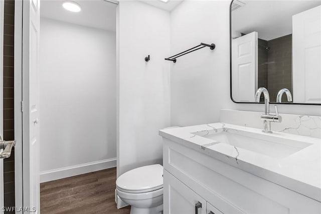 full bath with visible vents, wood finished floors, vanity, baseboards, and toilet
