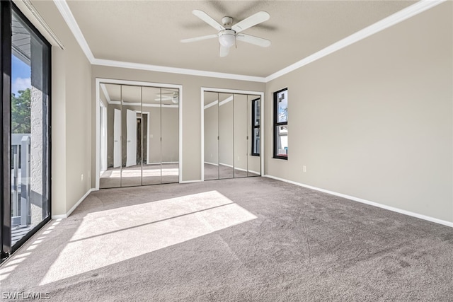 unfurnished bedroom featuring carpet, ornamental molding, and multiple windows