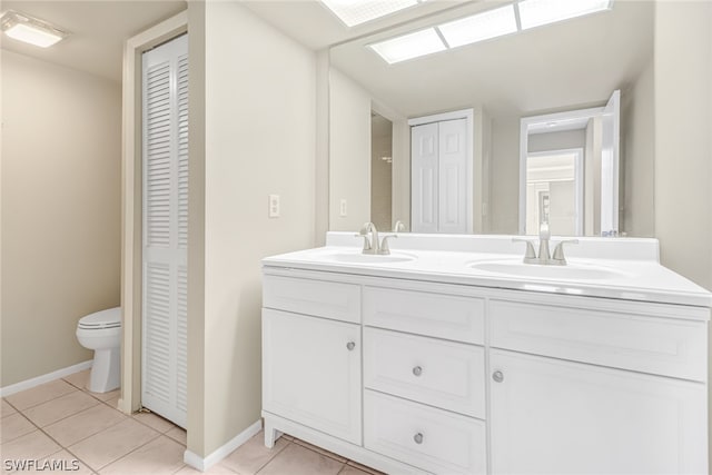 bathroom with dual bowl vanity, toilet, and tile floors