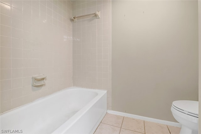 bathroom with tile floors, toilet, and tiled shower / bath combo