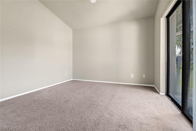 carpeted empty room with baseboards and lofted ceiling