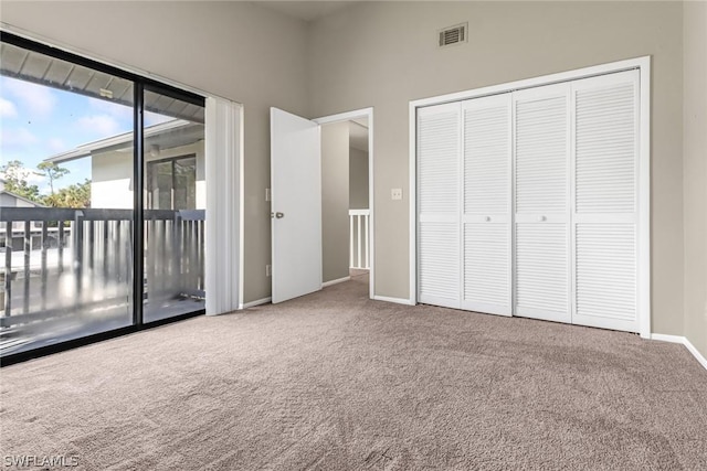 unfurnished bedroom featuring visible vents, carpet floors, a closet, access to exterior, and baseboards
