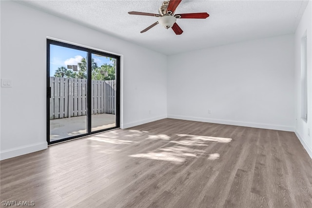 empty room with wood-type flooring, ceiling fan, and a textured ceiling