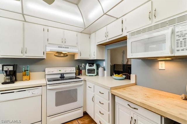 kitchen featuring white appliances, white cabinets, light countertops, under cabinet range hood, and light tile patterned flooring