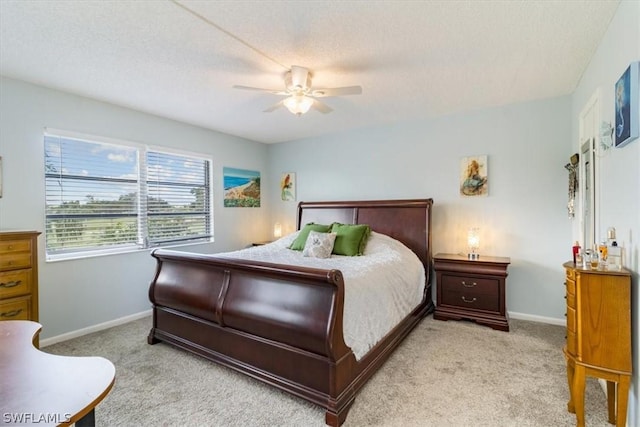 bedroom featuring baseboards, ceiling fan, a textured ceiling, and light colored carpet