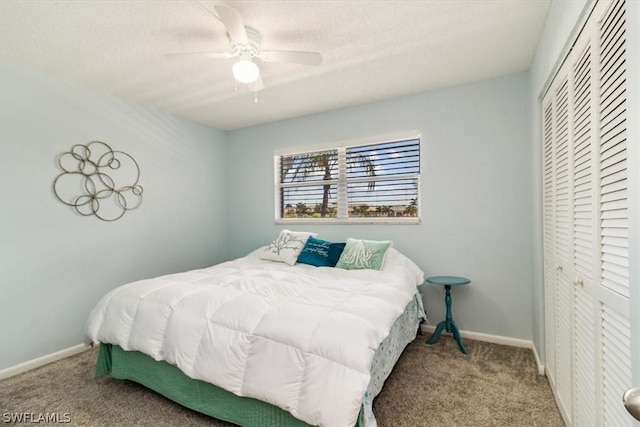 bedroom with a closet, a ceiling fan, carpet flooring, a textured ceiling, and baseboards