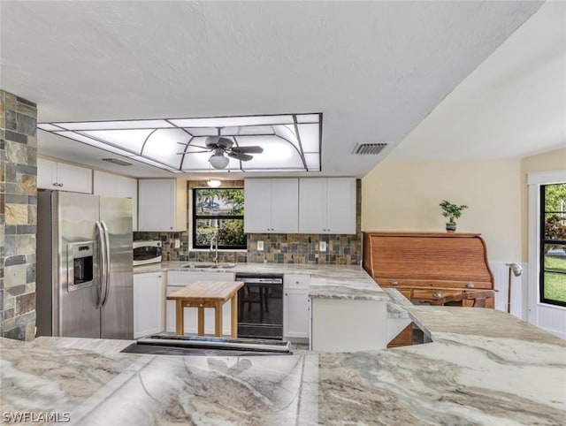 kitchen featuring white cabinetry, tasteful backsplash, stainless steel fridge, and dishwasher