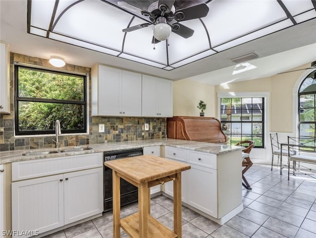 kitchen featuring sink, ceiling fan, black dishwasher, light stone counters, and white cabinetry