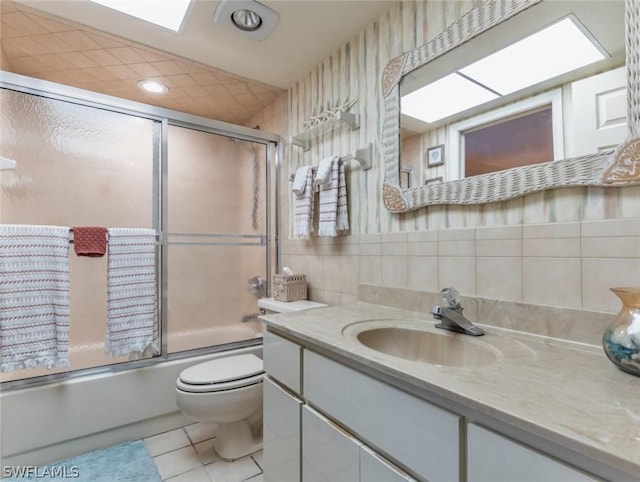 full bathroom featuring decorative backsplash, tile patterned floors, vanity, enclosed tub / shower combo, and toilet