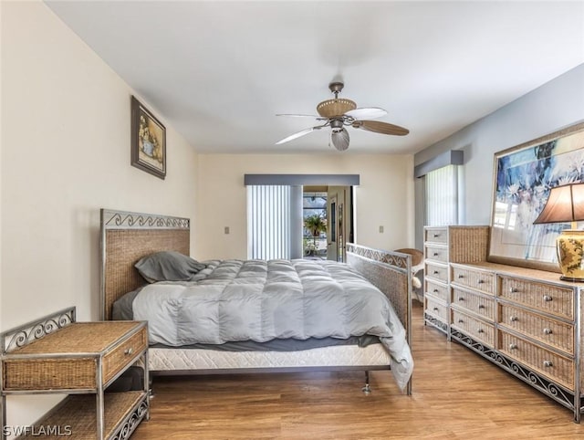 bedroom with hardwood / wood-style floors, ceiling fan, and access to outside