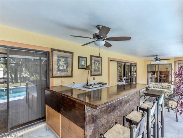 bar featuring ceiling fan and light tile patterned flooring