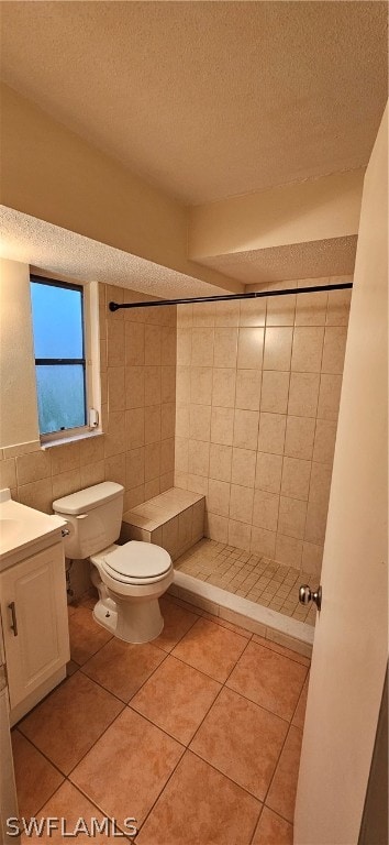 bathroom with tile flooring, tiled shower, tile walls, toilet, and vanity