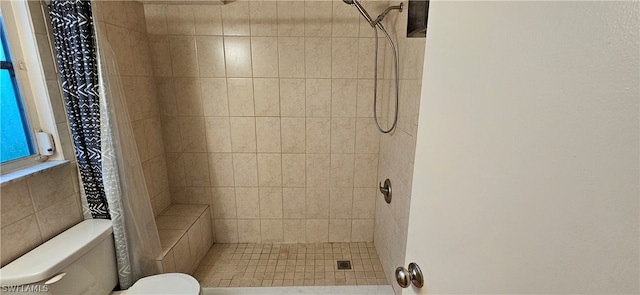 bathroom with tiled shower and toilet