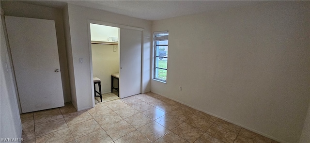 unfurnished bedroom featuring a closet and light tile flooring