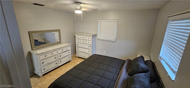 tiled bedroom featuring ceiling fan