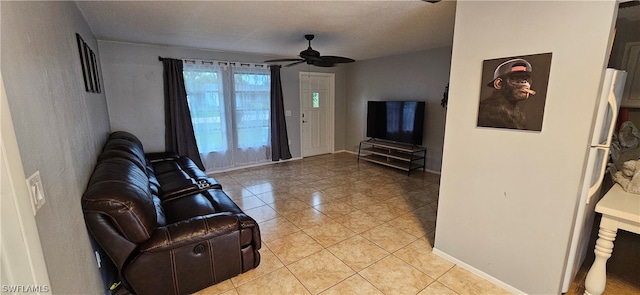 living room featuring a textured ceiling, ceiling fan, and light tile floors