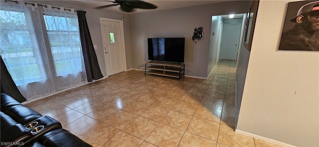 unfurnished living room featuring ceiling fan and light tile flooring